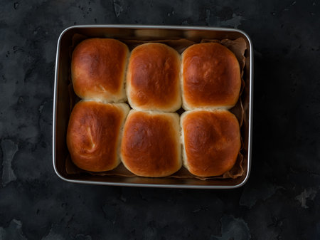 Homemade buns in a baking dish on a dark background, top viewの写真素材