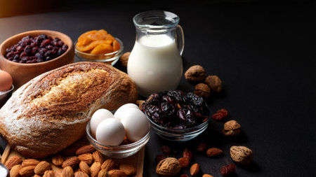 Bread, eggs, raisins, nuts and milk on a black backgroundの素材