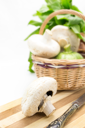 Mushrooms with wicker basket,greens and vegetables isolatedの写真素材