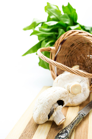 Mushrooms in wicker basket,greens and knife with copy-spaceの写真素材