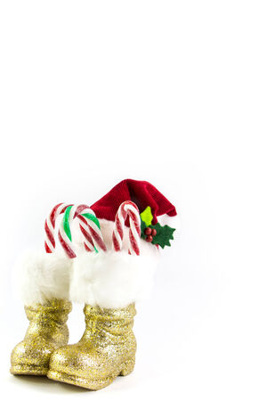 Santas golden boots and red hat with candy canes isolatedの写真素材