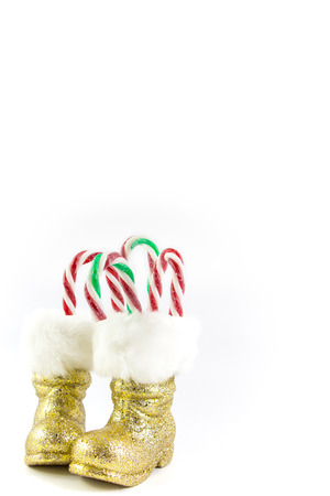 Santas golden boots with candy canes isolated on whiteの写真素材