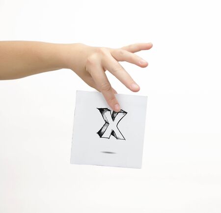 Hand holding a piece of paper with sketchy capital letter X, isolated on white.の写真素材