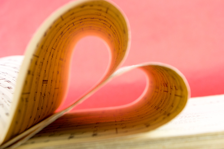 Music notation book with pages shaping heart closeupの写真素材