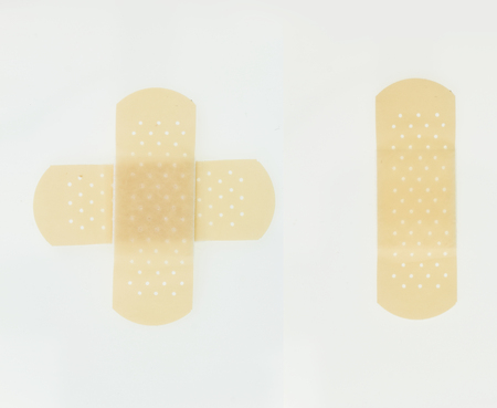 Plaster bands in cross shape and single, isolated on white background.の写真素材