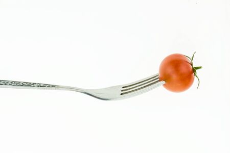 Cherry tomato on fork, on white background.の写真素材
