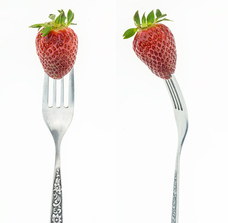 Fresh juicy strawberry on fork, front and side view, on white background.の写真素材