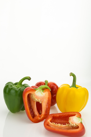 Fresh bell peppers, one cut in half, isolated on white background with copy-spaceの写真素材