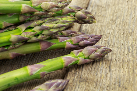 Bunch of asparagus tips closeup on wooden surfaceの写真素材