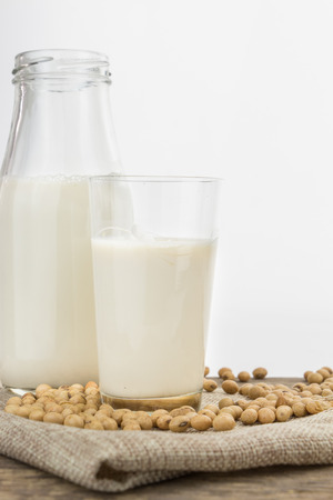 Bottle and glass of soy milk with soybeans, on white with copy-spaceの写真素材