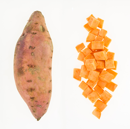 Fresh sweet potato whole and cut into cubes , isolated on white backgroundの写真素材