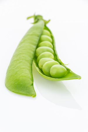 Fresh green pea pod vertical closeup, isolated on white backgroundの写真素材