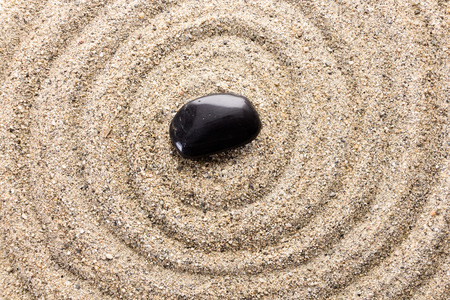 Black basalt stone on sand imitating water ripplesの写真素材