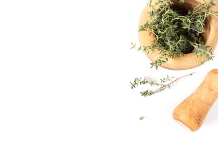 Fresh thyme in  wooden mortar with pestle, on withe background with copy-spaceの写真素材