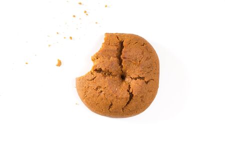 Bitten cookie with crumbs closeup, on white background.