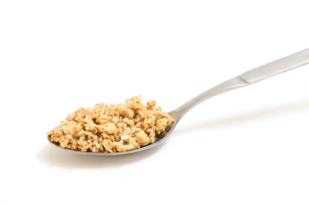 Spoon with granola, on white background.