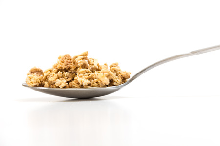 Spoon with granola, on white background.の写真素材