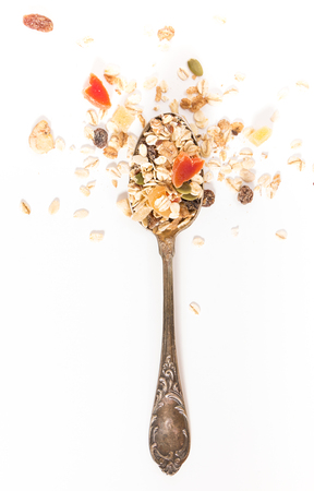 Spoon with muesli and dry fruits, on white background.の写真素材
