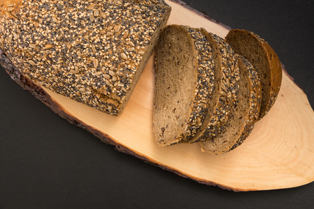 Whole wheat sliced bread closeup, on wooden surface.の写真素材