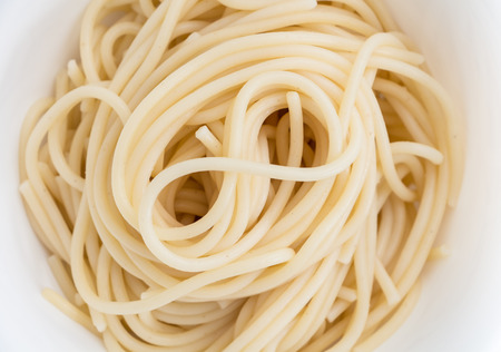 Plain cooked spaghetti pasta in white bowl, closeup background.の写真素材