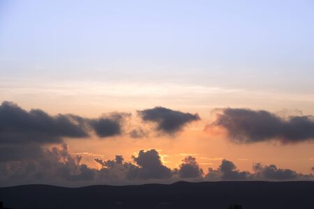 Colorful dawn/dusk sky with dark clouds background.の写真素材