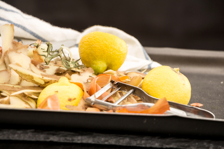 Fresh vegetable scraps with peeler and towel.の写真素材