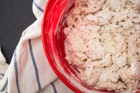 Making/mixing the dough in red bowl, baking preparation closeup.の写真素材