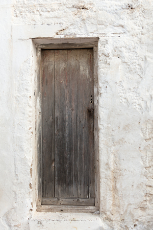 Old wooden door on grunge weathered wall.の写真素材