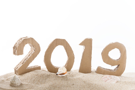 2019, handmade 3D numbers made of reused cardboard paper, on sand and white background.の写真素材