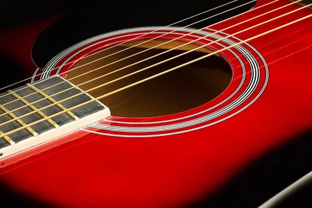 Closeup of a six stringed red acoustic guitar. Music entertainment background.の写真素材