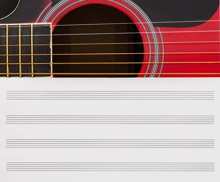 Blank music notebook page with copy-space, on red guitar with six strings. Musical education concept.の写真素材