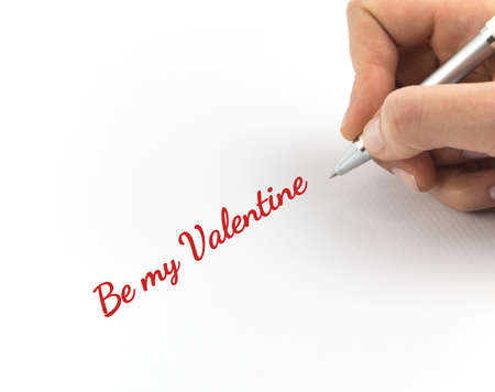 Hand writing "Be my Valentine" on white sheet of paper.の写真素材