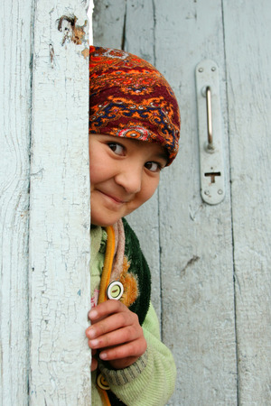 TASHKENT, UZBEKISTAN - March 12, 2009 : Portrait of an Uzbek beautiful girl in Uzbekistan. The girl looks out from behind the door.のeditorial素材
