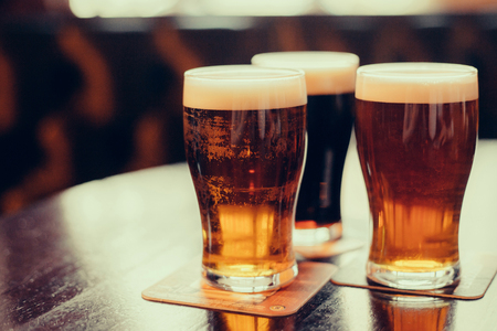 Glasses of light and dark beer on a pub background.の写真素材