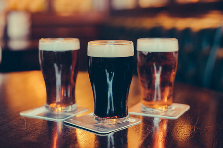 Glasses of light and dark beer on a pub background.の写真素材