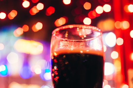 dark beer in the Christmas colored light backgroundの写真素材