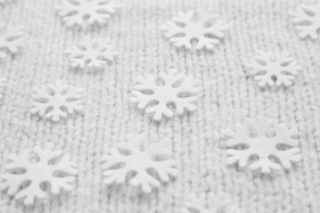 White snowflakes are on the knitted backgroundの写真素材