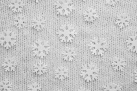 White snowflakes are on the knitted backgroundの写真素材