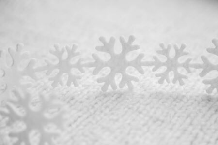 White snowflakes are on the knitted backgroundの写真素材