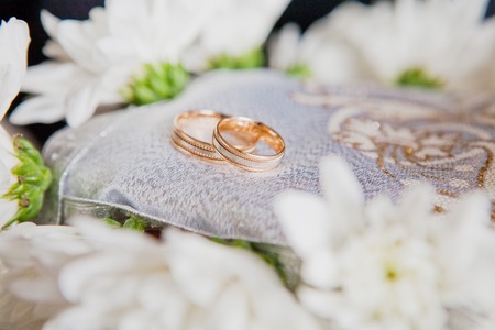 gold wedding rings on a pillowの写真素材