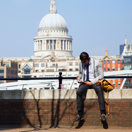 UK, London - 08 April 2015: An unknown man sitting reading on the background of St. Paul's Cathedral in Londonのeditorial素材