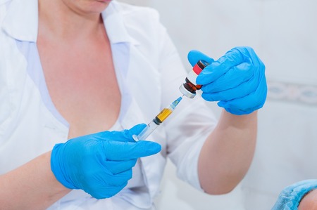 Cosmetic mesotherapy procedure - Syringe, medical injection in hand, palm or fingers. Medicine plastic vaccination equipment with needle.の写真素材