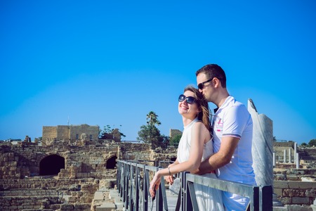 Happy romantic couple embracing each other against the background of the ruins of the ancient cityの写真素材