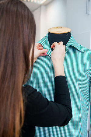 Female seamstress prepares a man's shirt to the fitting. Selective focusの写真素材