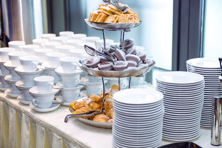 Catering table with dishes and snacks on the business event in the hotel hall. Close up, selective focus.の写真素材