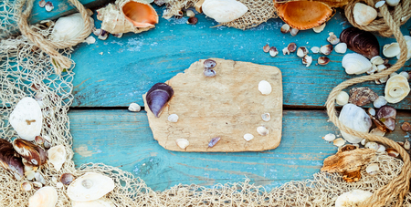 Summer vacation relaxation background theme with seashells, fishing net, rope, stones and weathered...
