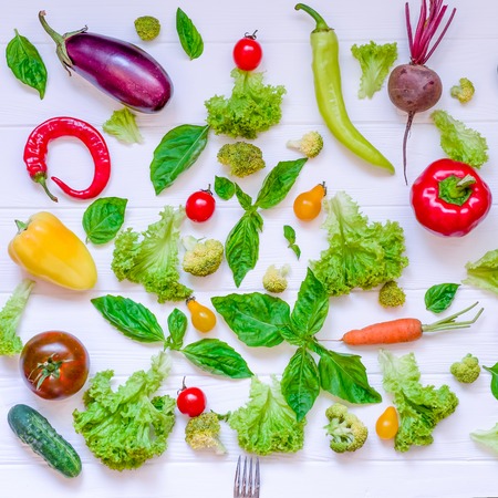 Collection of fresh organic vegetables and greeens on white wooden table. Top view. Healthy foods,...