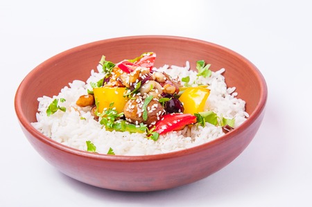 Chinese chicken sweet and sour sauce, served with rice and vegetables in the ceramic bowl on the white background isolated. Selective focus.の写真素材