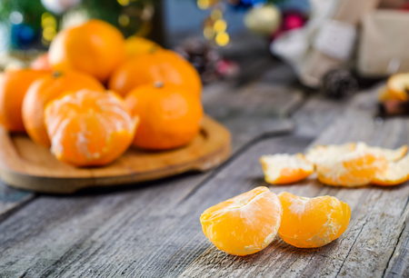 Christmas concept with Tangerines, Fir branches with decor , gifts and spices on the old rustic wooden table. New year background. Selective focus. Vintage toning. Space for textの写真素材