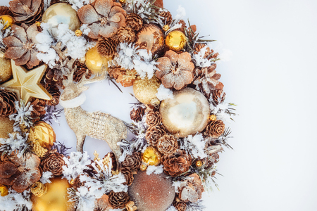 Top view Beautiful hand made golden Christmas wreath decorated with pine cones, ornamentals, spruce branches, balls, stars and decorative deer on white background isolated, flat lay. Copy spaceの写真素材